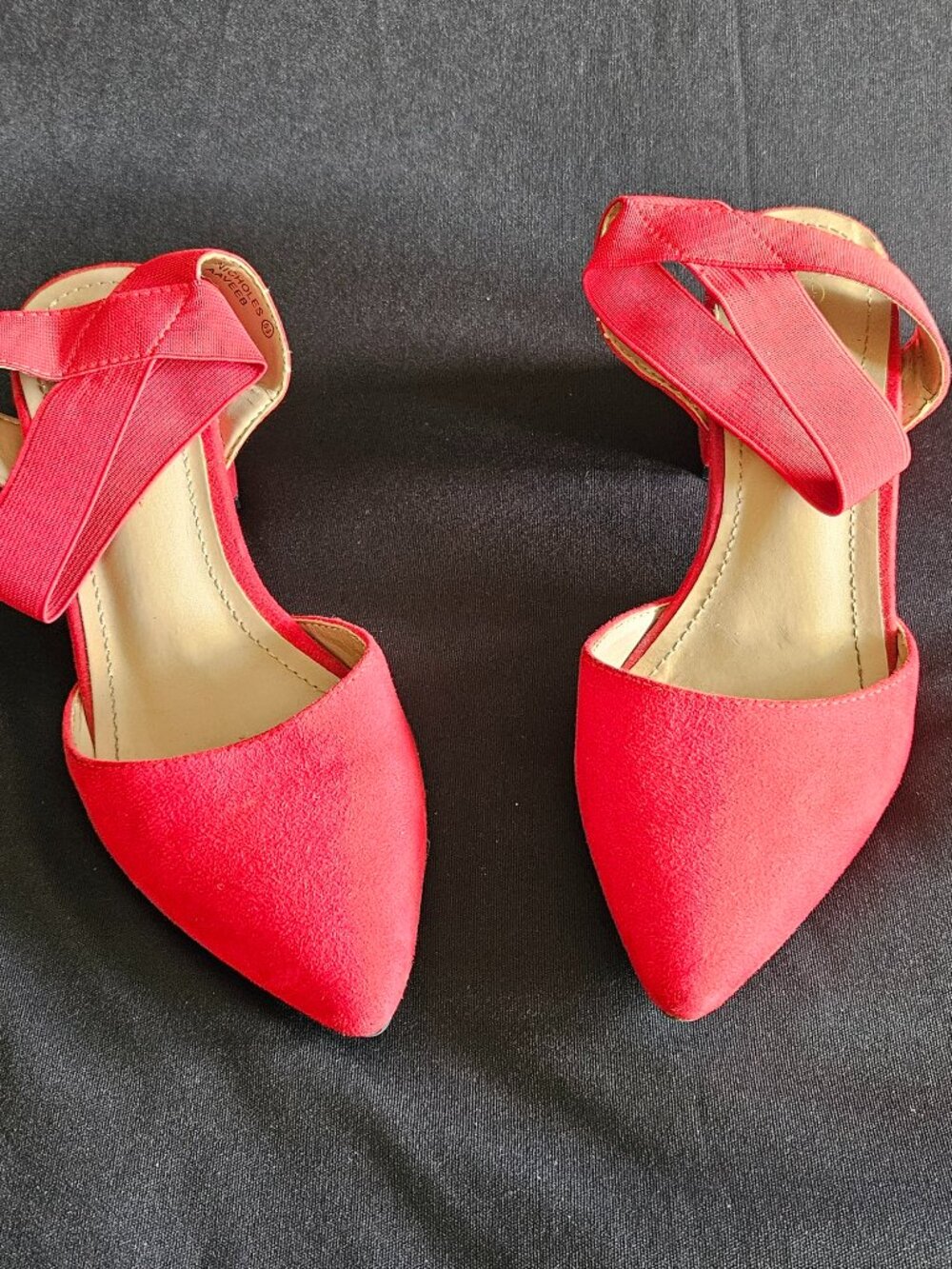 Pointy red block heels with stretchy ankle strap.